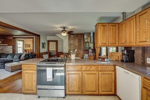 A modern kitchen with wooden cabinets, a stainless steel stove, and a granite countertop.