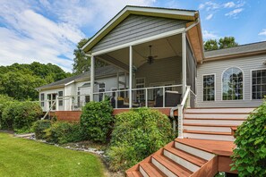 A two-story house with a covered porch, a staircase leading to the upper level, and a well-maintained garden.