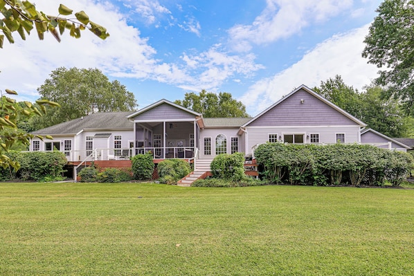 A two-story house with a covered porch and a front yard.