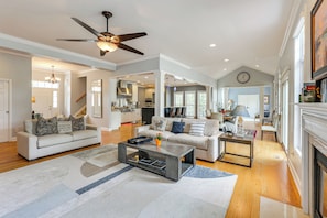 A spacious living room with a fireplace, a dining area, and a kitchen.