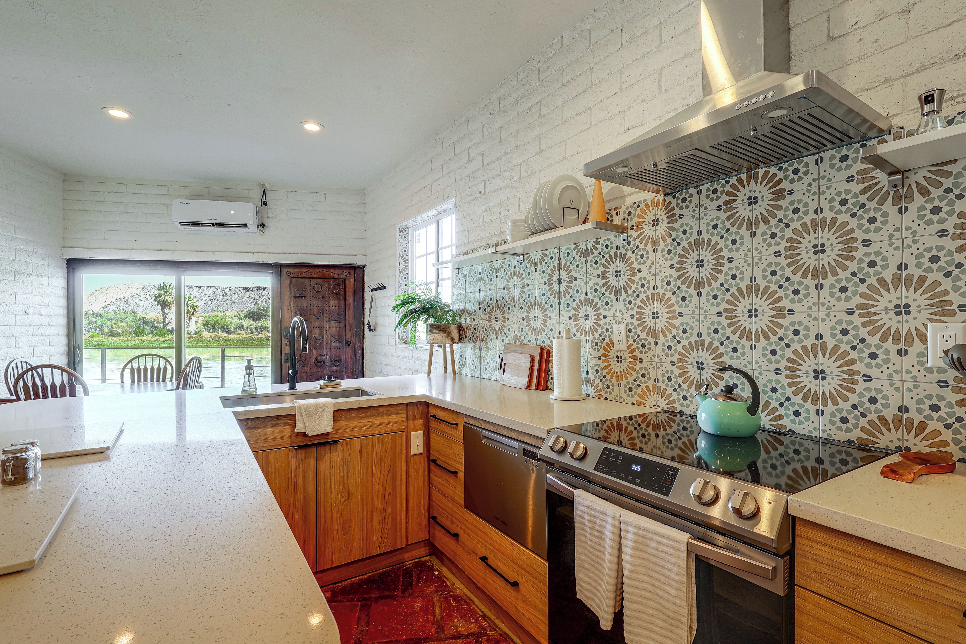 A modern kitchen with a central island, stainless steel appliances, and a decorative backsplash.