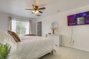 A bedroom with a bed, a ceiling fan, a TV, and a window with blinds. - 13 Mi to Beach! Family Getaway in Port St Lucie (Port Saint Lucie)