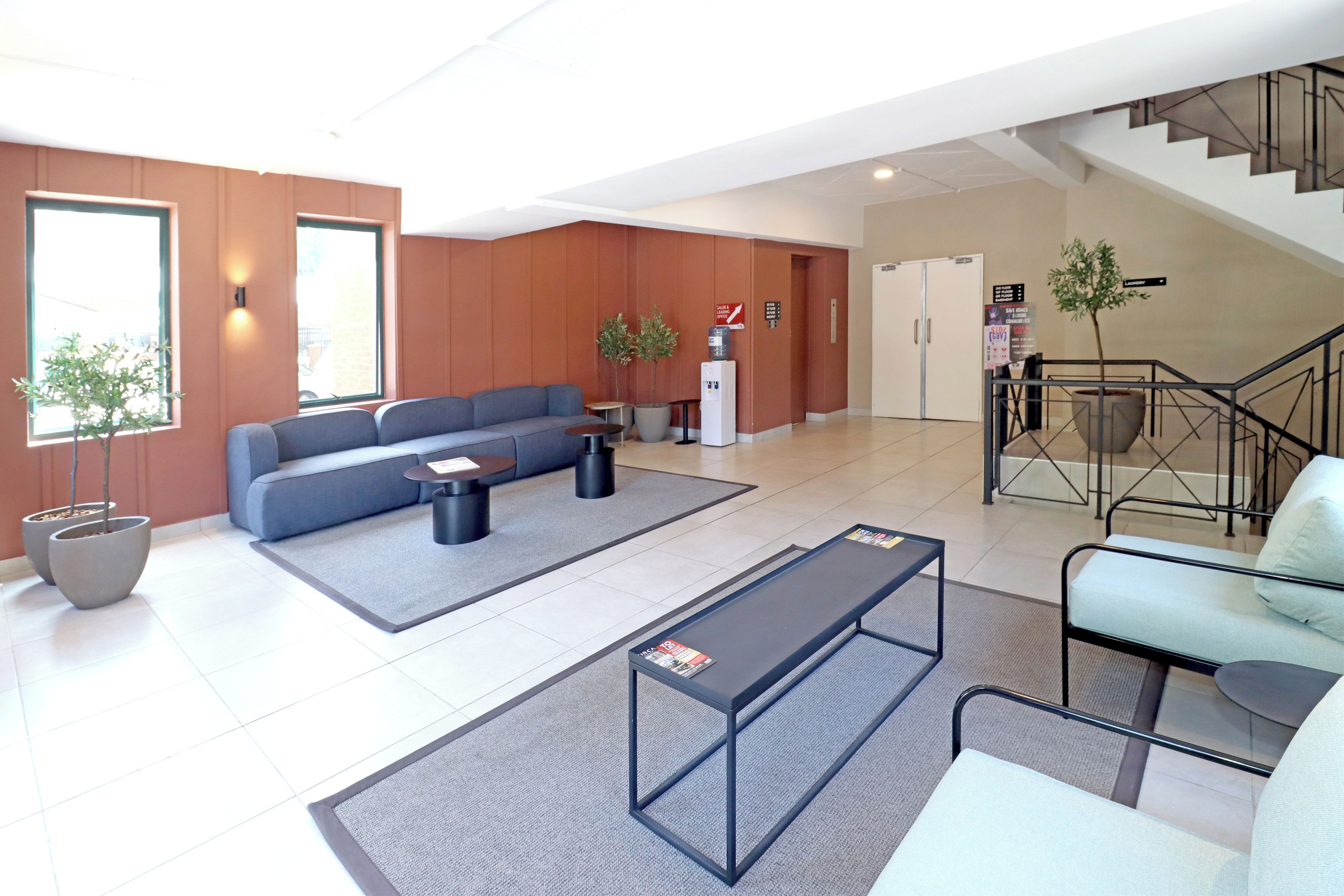 A modern lobby with a sofa, coffee table, and seating area.