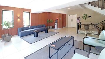 A modern lobby with a sofa, coffee table, and seating area.