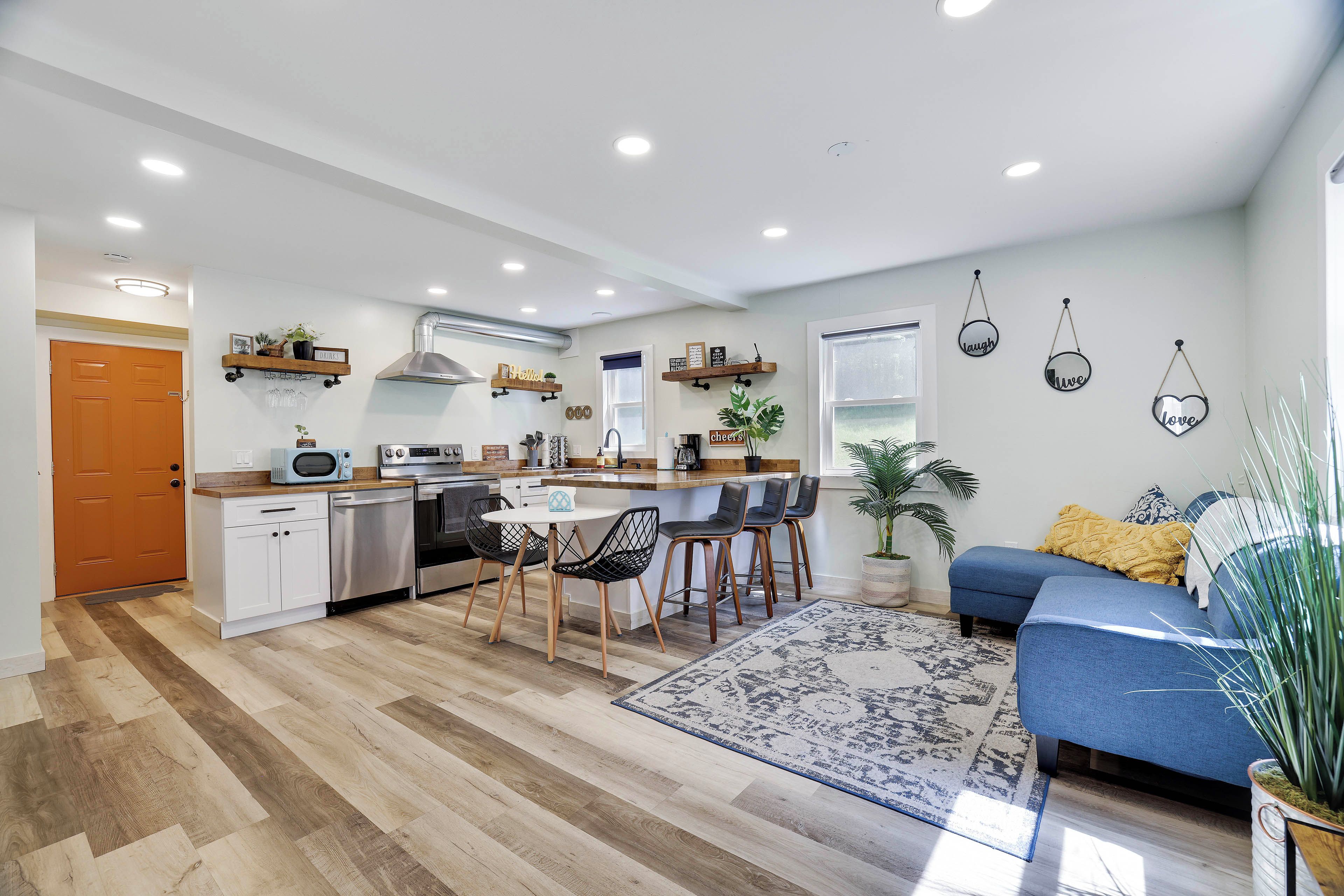 Una cocina moderna con una isla central, taburetes de bar y una mesa de comedor.