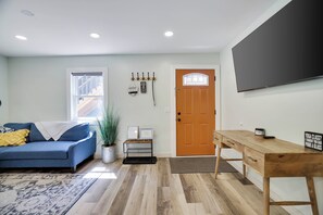 A living room with a blue sofa, a wooden coffee table, a potted plant, and a door with a window. - Poconos Mtn Getaway: 4 Mi to Camelback Resort (Tannersville)