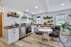 A modern kitchen with white cabinetry, a built-in oven, a microwave, and a dining area with a round table and chairs. - Poconos Mtn Getaway: 4 Mi to Camelback Resort (Tannersville)
