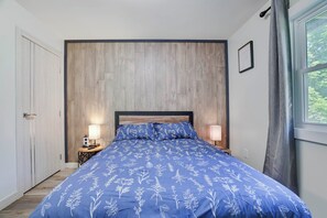 A bedroom with a bed, two bedside lamps, a wooden headboard, a window with curtains, and a door. - Poconos Mtn Getaway: 4 Mi to Camelback Resort (Tannersville)