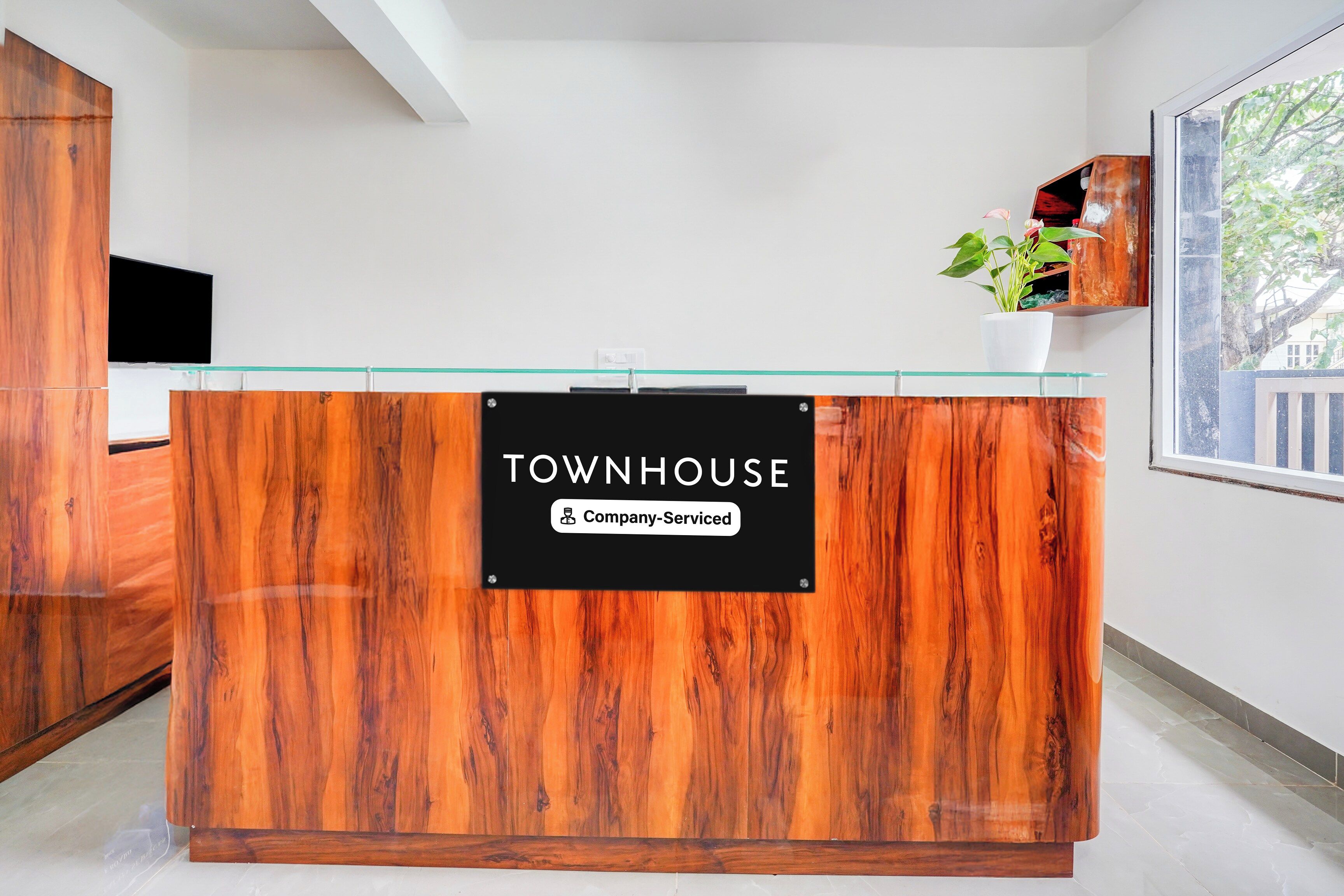 A reception desk with a sign that reads 'TOWNHOUSE Company-Serviced.'
