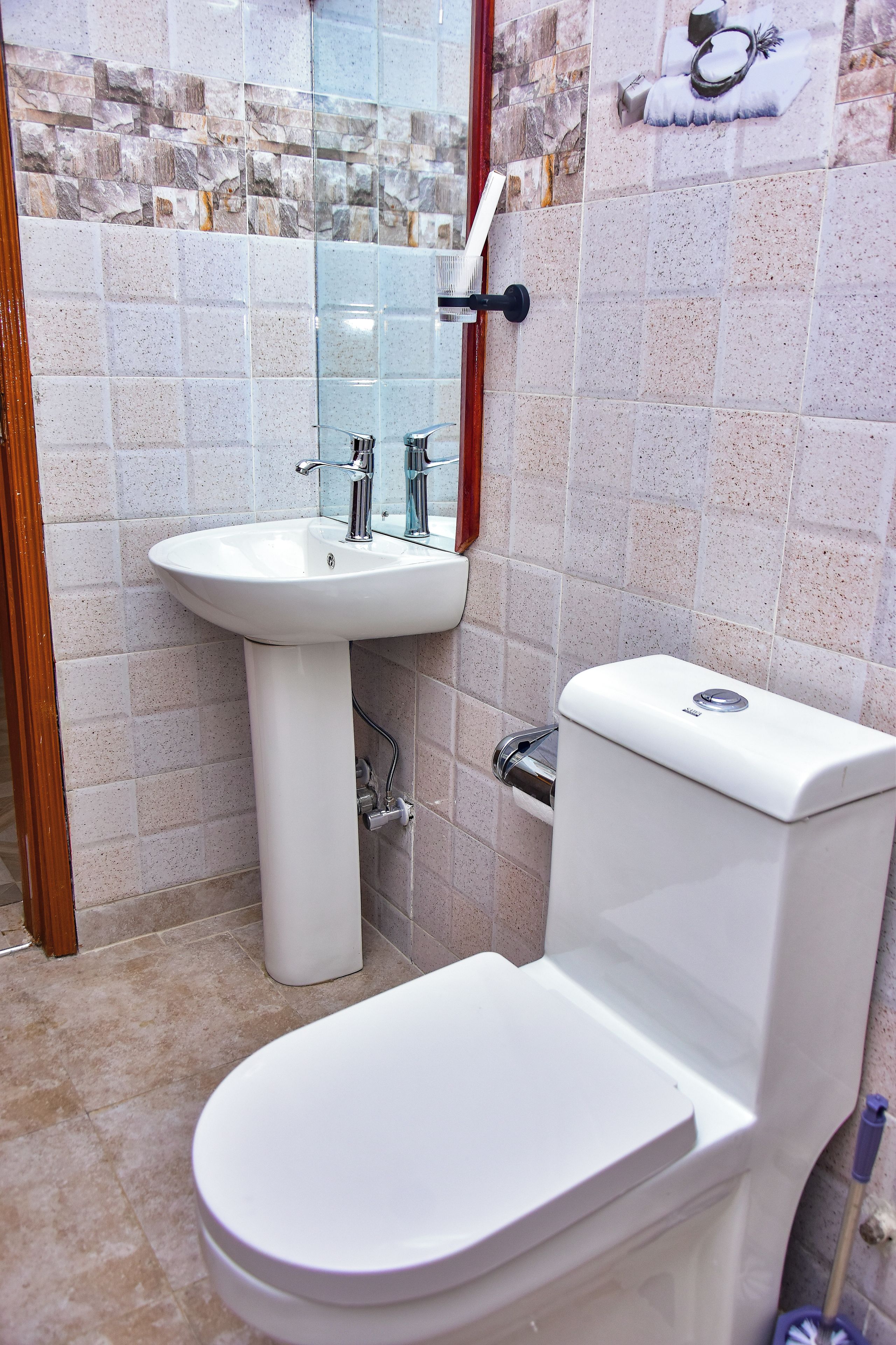 Un baño con lavamanos blanco, inodoro y zona de ducha.