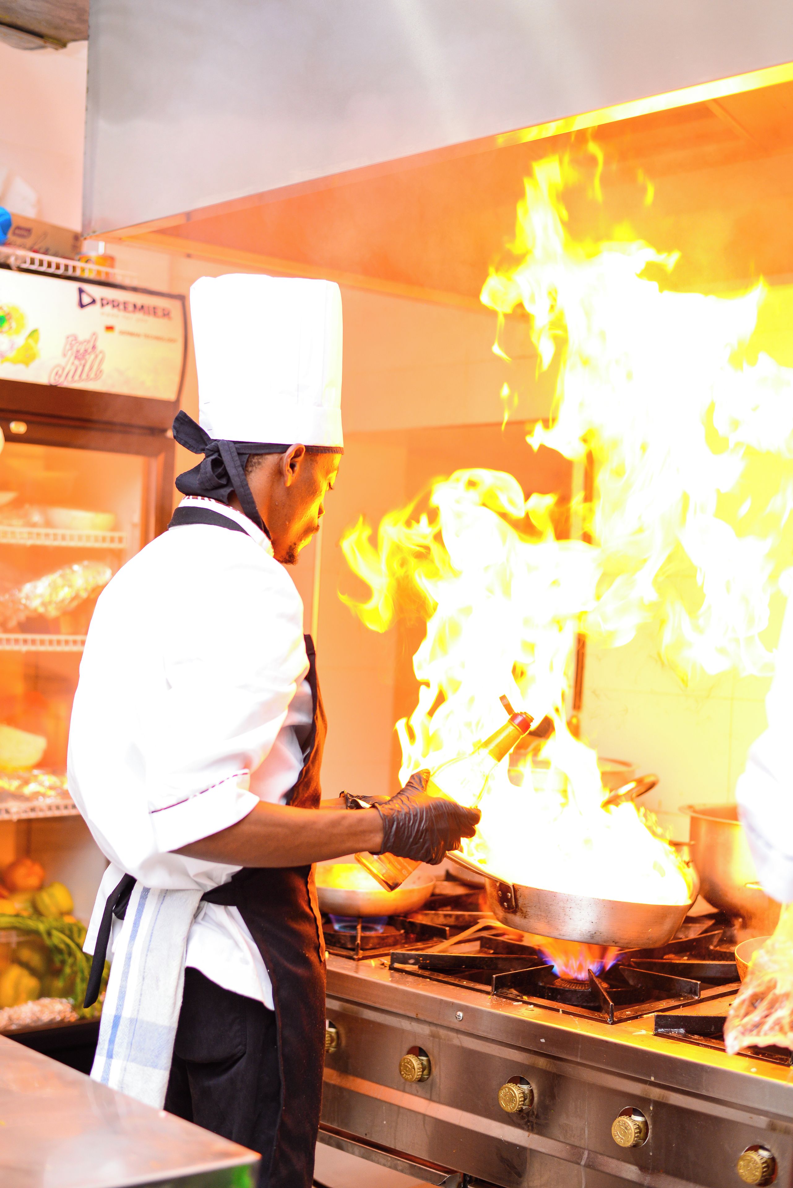 Un chef cuisinant avec une grande flamme.