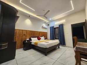 Un dormitorio con cama, mesita de noche y ventilador de techo.
