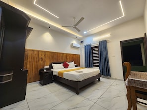 Ein modernes Hotelzimmer mit Bett, Nachttisch und Deckenventilator.