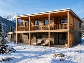 A two-story wooden chalet with a stone facade, balconies, and a snow-covered landscape. - Modern chalet, pets welcome - 16 guests by the slopes (Vars)