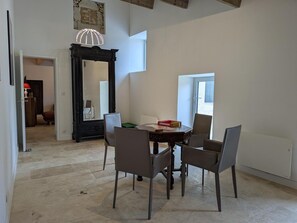 A dining area with a table, chairs, a mirror, and a pendant light. - Welcoming house, pets OK - 8 guests (Nanteuil-en-Vallée)