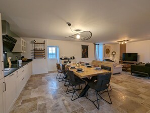 A modern kitchen with a dining area, a sofa, and a TV in a living space. - House with pool - 8 guests (Saint-Amant-de-Nouère)