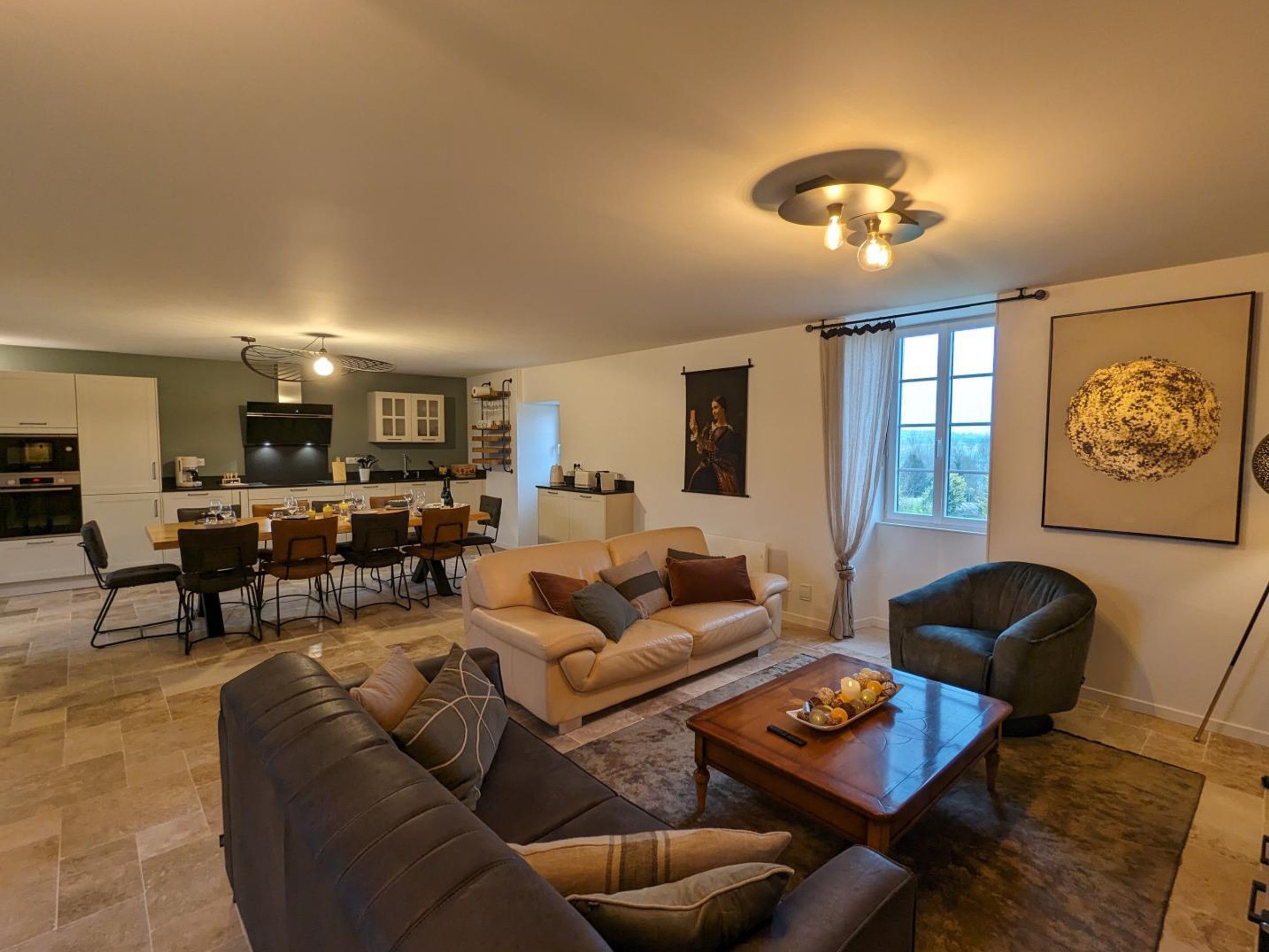 Een moderne woonkamer met een bank, salontafel en een eethoek met stoelen en een tafel.