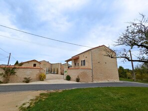 A row of traditional stone buildings with a paved driveway and a grassy area in front. - House with pool - 8 guests (Saint-Amant-de-Nouère)