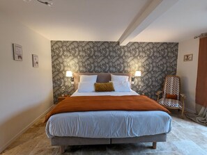 A bed with a headboard, two bedside lamps, a brown throw blanket, and a patterned wallpaper. - House with pool - 8 guests (Saint-Amant-de-Nouère)
