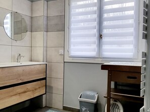 A bathroom with a sink, mirror, window with blinds, and a trash bin. - Spacious house, preserved nature - Total serenity (CASSEL)