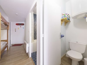 A compact room with a bunk bed, a shower with a glass door, a toilet, and a shelf with cleaning supplies. - Studio with mountain view - 6 guests (Gourette)