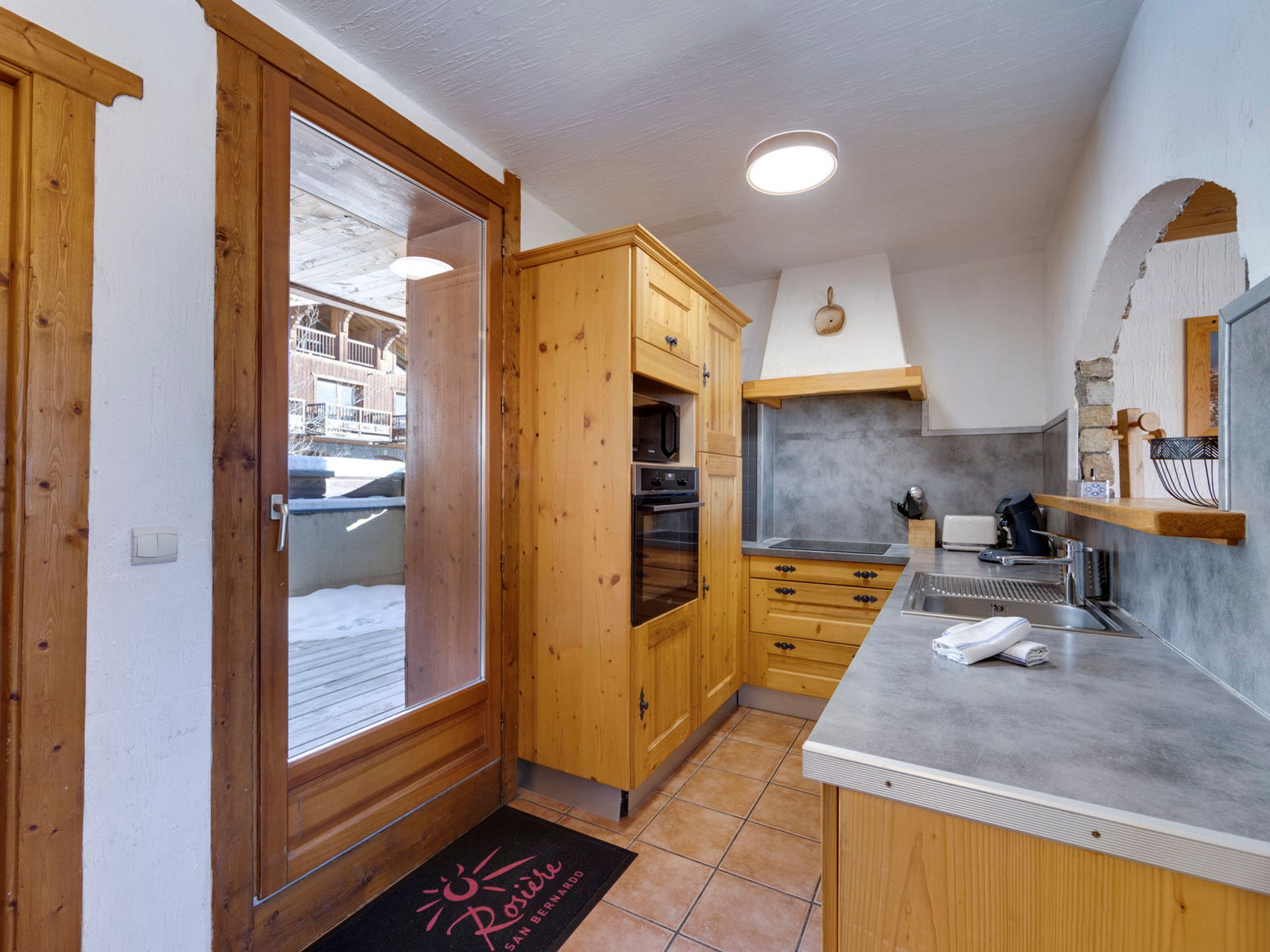 A kitchen with wooden cabinets, a countertop, and a built-in oven.