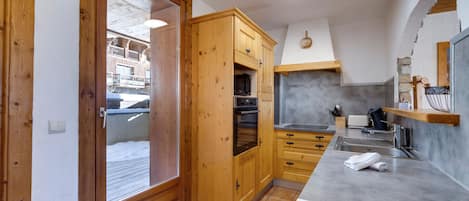 Una cocina con armarios de madera, una encimera y un horno empotrado.