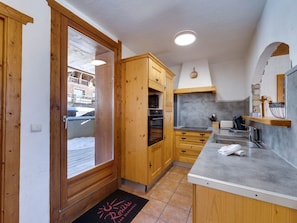 Eine Küche mit Holzausstattung, einer Arbeitsplatte und einem eingebauten Backofen.