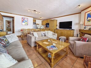 A living room with sofas, a coffee table, and a television. - Spacious 75m² Apartment, Ski-in/Ski-out, Southwest Balcony (Les Menuires)