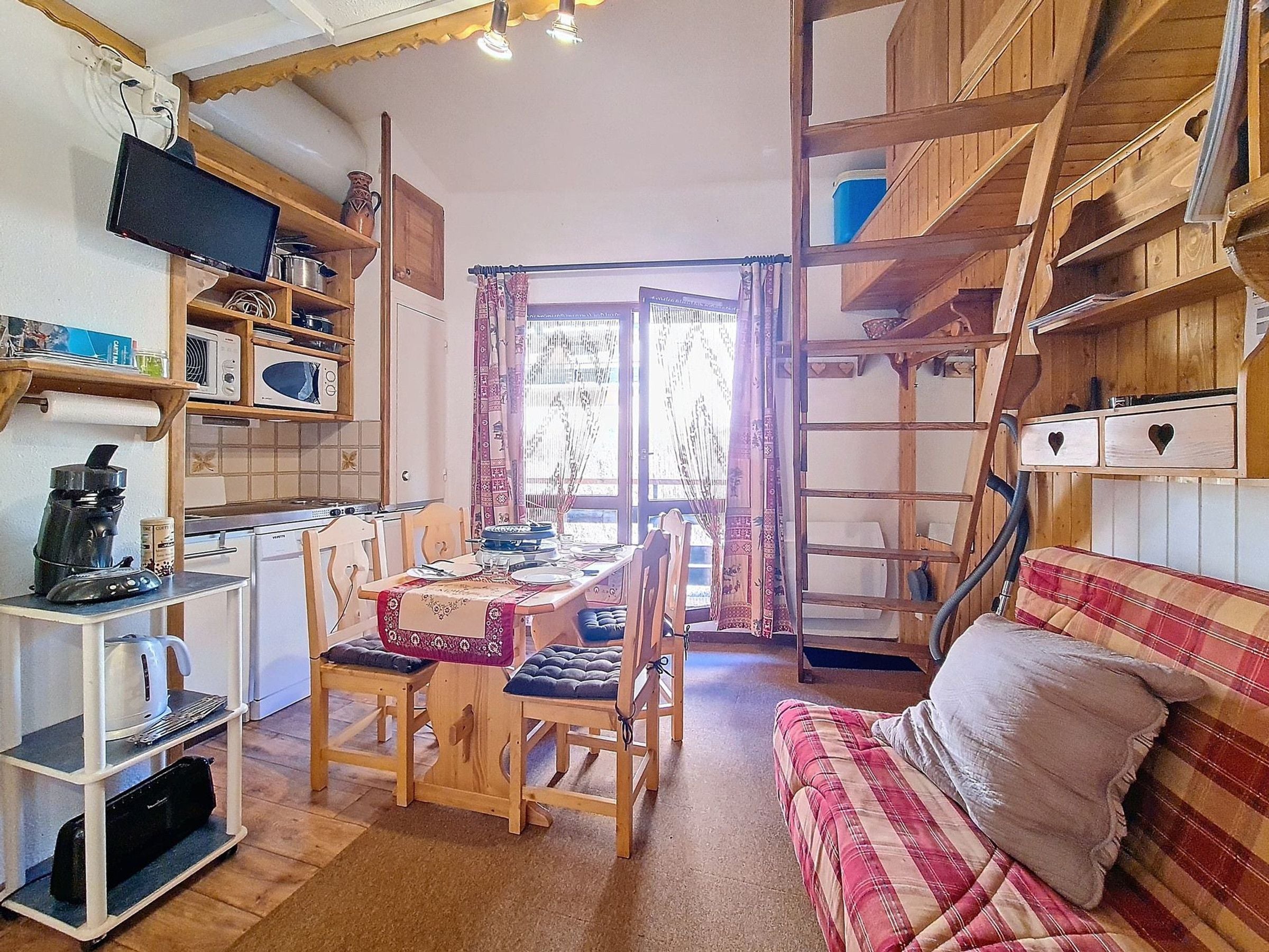 Eine gemütliche Küche mit Holzausstattung, einem Esstisch für vier Personen und einem Sofa im Wohnbereich.
