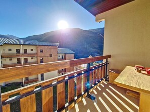 A balcony with a wooden railing overlooking a mountain landscape. - Two-room apartment, mountain view - 4 guests (Les Menuires)