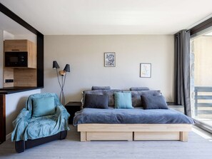 A modern bedroom with a bed, bedside tables, a chair, a wardrobe, and a window. - Mountain studio - 4 guests (Saint-Lary-Soulan)