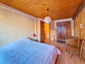 Ein Zimmer mit einem Bett, einem Holzschrank, einem Schreibtisch und einer Mannequin.