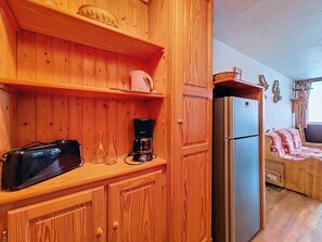 A wooden kitchen with a refrigerator, a coffee maker, and a microwave. - Spacious apartment - 6 guests at the foot of the slopes (Les Menuires)
