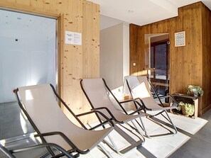 A waiting area with wooden panel walls, a small table with plants, and three reclining chairs. - Spacious 7-room apartment near slopes with sauna, hammam, and wifi (Les Menuires)