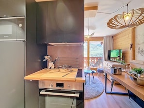 A modern kitchen with a Bosch refrigerator, a built-in oven, and a wooden countertop. - Renovated apartment with balcony, ski-in/ski-out, 4 people (Les Menuires)