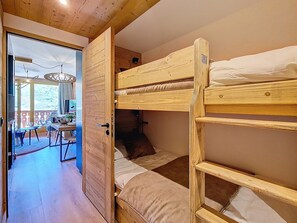 Et værelse med køjeseng, et spiseområde med bord og stole samt udsigt til det fri.