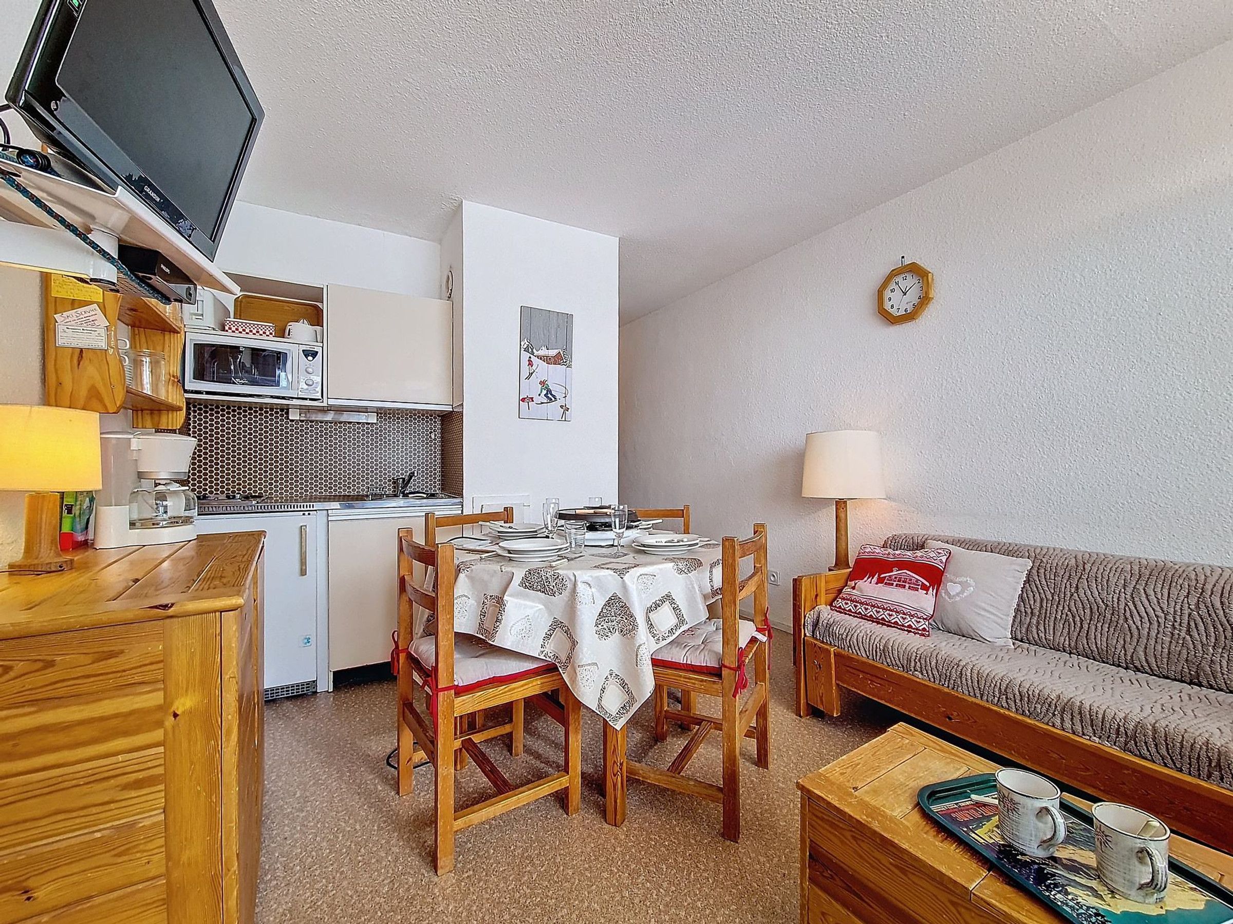 A compact living space with a kitchenette, dining area, and seating area.