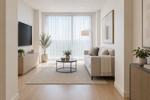 Un salon moderne avec un canapé, une table basse et un téléviseur fixé au mur.