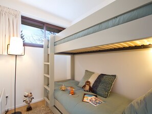 A bunk bed with a ladder, a bedside lamp, a plush toy, and a magazine on the bed. - Bright apartment 75sqm, calm, near slopes - 6 guests (Les Deux Alpes)