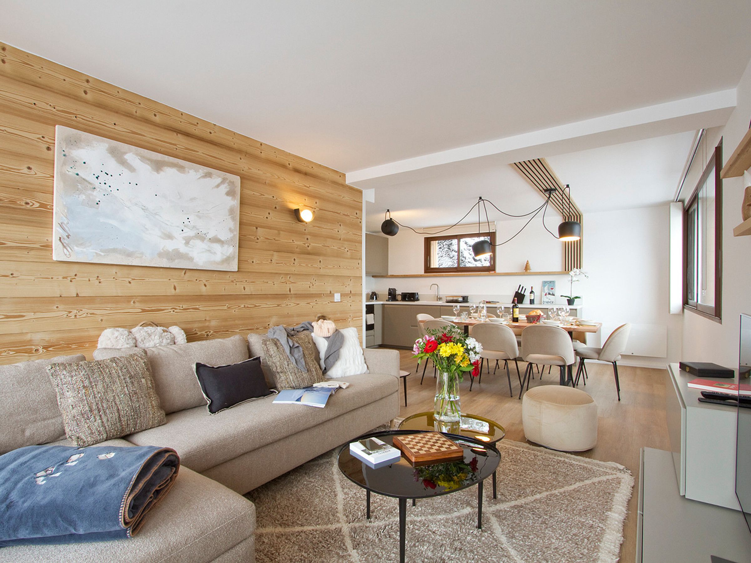 Una sala de estar moderna con un sofá, una mesa de centro y un comedor con sillas y una mesa.