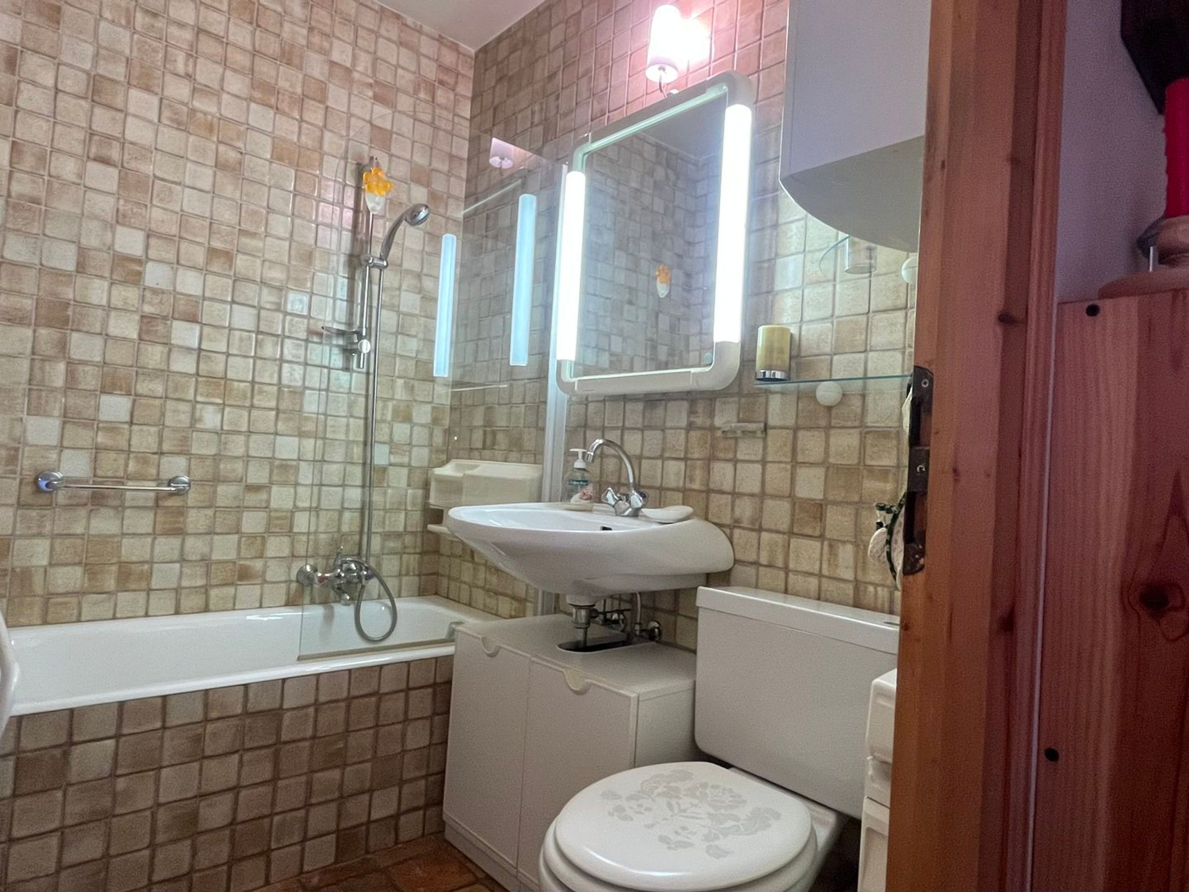 A bathroom with a bathtub, a sink, a toilet, and a mirror.