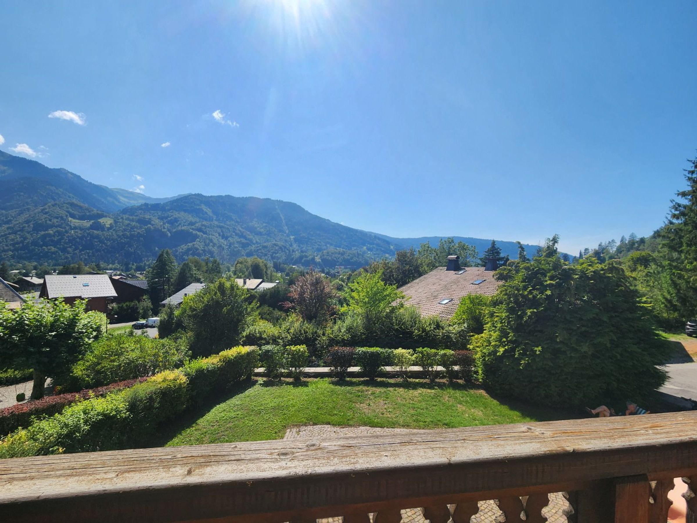 A residential area with houses, a wooden fence, and a mountain backdrop.