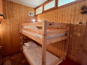 A bunk bed in a wooden room with a framed picture on the wall. - Apartment, pets OK - mountain view (4 guests) (Samoëns)