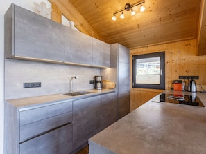 A modern kitchen with grey cabinetry, a stainless steel sink, and a window providing natural light. - Cabin in Pichl Near Schladming With Sauna (Schladming)