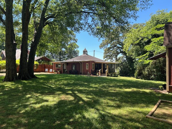 A residential property with a house, a fenced yard, and mature trees.