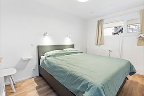 A bedroom with a bed, a desk, and a window with curtains. - 2 bedroom accommodation in Middelkerke (Middelkerke)