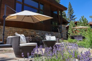 A patio area with outdoor furniture, a stone wall, and a view of a mountain. - Gray's Crossing Golf Estate 4 Bedroom Home (Truckee)