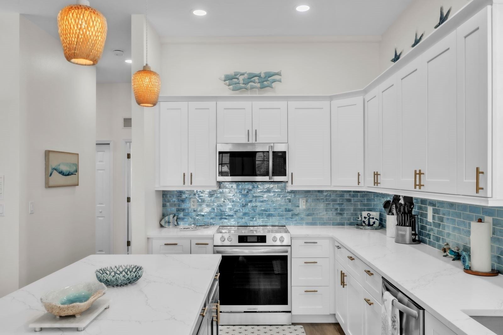 A modern kitchen with white cabinetry, a blue-tiled backsplash, and stainless steel appliances.