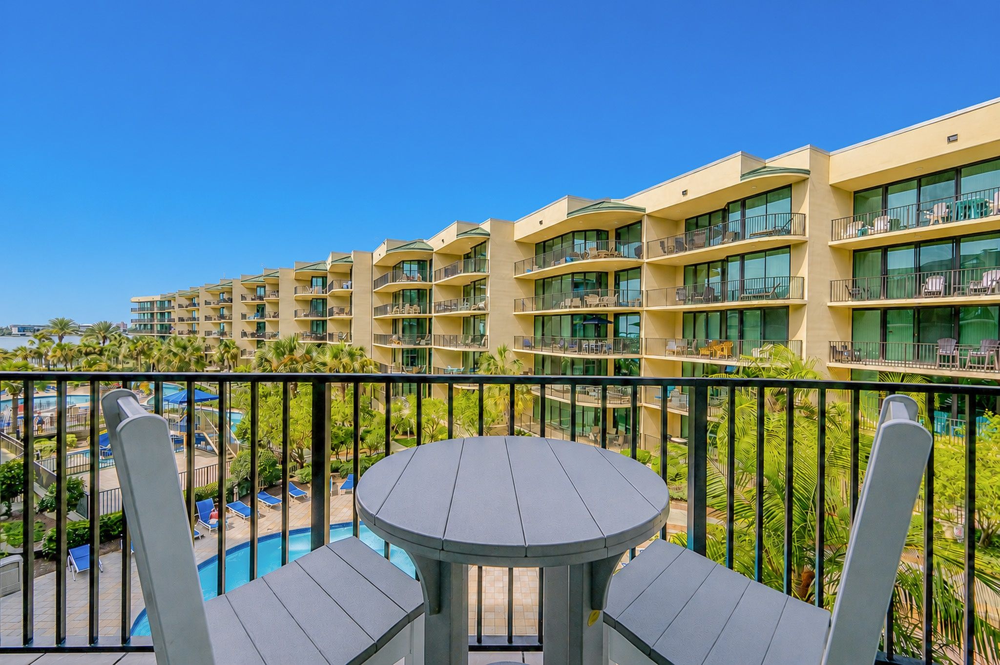 Ein Hotelbalkon mit Pool, mehrere Etagen mit Balkonen und freier Aussicht auf die Umgebung.